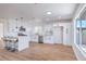 Bright kitchen boasts white cabinets, stainless steel appliances, and a large island with bar stool seating at 6420 Rosemount Ave, Las Vegas, NV 89156