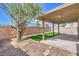 Backyard patio featuring an inviting covered area and well-maintained synthetic lawn at 6420 Rosemount Ave, Las Vegas, NV 89156