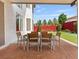 Covered back patio with outdoor dining set and lush backyard view at 6639 Tranquil Seas Ct, Las Vegas, NV 89139