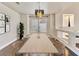 Bright dining room featuring a modern chandelier, large window, seating for six, and modern decor at 6639 Tranquil Seas Ct, Las Vegas, NV 89139
