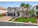 Beautiful two-story home with a brick driveway, lush lawn, and attractive desert landscaping at 6639 Tranquil Seas Ct, Las Vegas, NV 89139