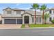 Beautiful two-story home featuring a three-car garage, manicured lawn, and beautiful palm trees at 6639 Tranquil Seas Ct, Las Vegas, NV 89139