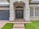 Contemporary double front doors framed by elegant columns, set against a backdrop of lush green lawn at 6639 Tranquil Seas Ct, Las Vegas, NV 89139