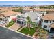 Attractive two-story home with a lush green lawn, mature palm trees, and a brick-paved driveway at 6639 Tranquil Seas Ct, Las Vegas, NV 89139