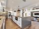 Modern kitchen featuring a large island, white cabinets, and stainless steel appliances and hardwood floors at 6639 Tranquil Seas Ct, Las Vegas, NV 89139