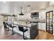 Modern kitchen showcasing a large island, stylish stools, designer backsplash, and stainless steel appliances at 6639 Tranquil Seas Ct, Las Vegas, NV 89139
