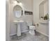 Charming powder room features pedestal sink, neutral paint, decorative shelf and updated tile flooring at 6639 Tranquil Seas Ct, Las Vegas, NV 89139