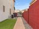 Side yard with artificial grass and stone pathway leading to a gated area at 6639 Tranquil Seas Ct, Las Vegas, NV 89139