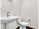 This is a traditional bathroom with a pedestal sink, toilet, and round mirror at 6952 Crescent Gold St, North Las Vegas, NV 89086