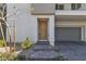 Charming townhome entrance featuring a covered entry and a two-car garage at 6952 Crescent Gold St, North Las Vegas, NV 89086
