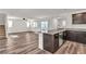 Open living space with wood-look flooring, staircase, and kitchen area with counter seating at 6952 Crescent Gold St, North Las Vegas, NV 89086