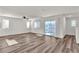 Bright, open living room with wood-look floors, natural light, and sliding door to exterior at 6952 Crescent Gold St, North Las Vegas, NV 89086
