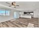 Bright and open-concept living space with windows, fan, kitchen, and sliding door to balcony at 6952 Crescent Gold St, North Las Vegas, NV 89086
