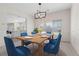 Well-lit dining room features a wood table, modern chandelier, and large window overlooking the yard at 7221 Harlow St, Las Vegas, NV 89131