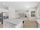 Bright open kitchen with stainless steel appliances, white cabinets, and views of the living room fireplace at 7221 Harlow St, Las Vegas, NV 89131