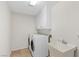 Functional laundry room with modern washer, dryer, sink, and upper storage cabinets at 7221 Harlow St, Las Vegas, NV 89131