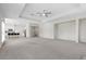 Expansive living room with neutral carpet, tray ceiling, and adjacent kitchen at 7221 Harlow St, Las Vegas, NV 89131