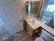 Bathroom featuring wood-look floors, a white single sink vanity, and a mirrored medicine cabinet at 7249 Linaria Rd, Las Vegas, NV 89113