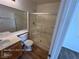 Bathroom featuring wood-look floors, a glass-enclosed shower, and a single sink vanity at 7249 Linaria Rd, Las Vegas, NV 89113