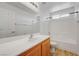 Well-lit bathroom with white tile, a large mirror, and a combination shower and bathtub at 7249 Linaria Rd, Las Vegas, NV 89113