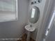 Bathroom with pedestal sink, oval mirror, and a window at 7249 Linaria Rd, Las Vegas, NV 89113