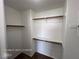 Spacious walk-in closet featuring white walls, wooden shelving and ample storage space at 7249 Linaria Rd, Las Vegas, NV 89113