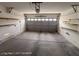 A clean and spacious garage featuring concrete floors, shelves, and a functional door at 7249 Linaria Rd, Las Vegas, NV 89113