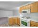 Kitchen showcasing wooden cabinetry, white countertops, and stainless appliances, adjacent carpeted living area at 7249 Linaria Rd, Las Vegas, NV 89113