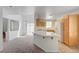 Bright kitchen featuring wooden cabinets, white countertops, and modern appliances with carpeted adjacent area at 7249 Linaria Rd, Las Vegas, NV 89113