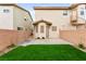 Low-maintenance backyard with artificial turf and a patio, enclosed by a brick wall for privacy at 7566 Glowing Ember Ct # 101, Las Vegas, NV 89130