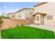 Private backyard featuring a patio and artificial turf, fully enclosed by a brick perimeter wall at 7566 Glowing Ember Ct # 101, Las Vegas, NV 89130