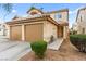 Front exterior with desert landscaping and a two-car garage at 7566 Glowing Ember Ct # 101, Las Vegas, NV 89130