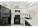 Updated kitchen with white cabinets, marble countertops, and black appliances at 7566 Glowing Ember Ct # 101, Las Vegas, NV 89130