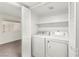 Convenient laundry room featuring a washer, dryer, and shelving for ample storage space at 7566 Glowing Ember Ct # 101, Las Vegas, NV 89130