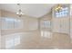 Bright living room boasts high ceilings, stylish chandeliers, tile floors, and large windows with shutters at 7711 Lofty Hill Ct, Las Vegas, NV 89123