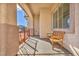Inviting covered porch with a wooden bench and neutral colored walls and columns at 7886 Palace Monaco Ave, Las Vegas, NV 89117
