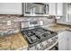 Gas range stove top and granite countertops in modern kitchen at 7886 Palace Monaco Ave, Las Vegas, NV 89117