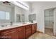 Bright bathroom with a double sink vanity and large mirror, plus an open closet for extra storage at 7908 Morning Gallop Ct, Las Vegas, NV 89131