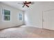 This bedroom is bright and spacious, featuring carpeted floors, a ceiling fan, and large windows at 7908 Morning Gallop Ct, Las Vegas, NV 89131