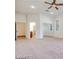 Spacious living room with neutral walls and carpets, ceiling fan and windows providing ample natural light at 7908 Morning Gallop Ct, Las Vegas, NV 89131