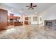 Open concept living space with fireplace and kitchen, plus stone tile flooring at 7908 Morning Gallop Ct, Las Vegas, NV 89131