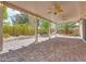 Covered patio featuring brick flooring, ceiling fans, and views of the landscaped backyard at 7908 Morning Gallop Ct, Las Vegas, NV 89131