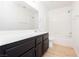 Bright bathroom featuring a single sink vanity with dark cabinets and tub-shower combo at 8224 Cassis Ct, Las Vegas, NV 89117