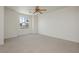 Large bedroom boasts neutral carpet, ceiling fan, and a window overlooking neighborhood at 8224 Cassis Ct, Las Vegas, NV 89117