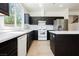 Bright kitchen features dark cabinetry, stainless steel appliances, and white marble countertops at 8224 Cassis Ct, Las Vegas, NV 89117