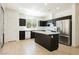 Modern kitchen features stainless steel appliances, island with white countertop, and black cabinetry at 8224 Cassis Ct, Las Vegas, NV 89117