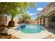 Backyard pool with a hot tub, surrounded by lush landscaping and a tiled deck, perfect for outdoor entertaining at 8224 Cassis Ct, Las Vegas, NV 89117