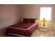 Bright bedroom showing block wall construction, with tile flooring, neutral wall color and a red bedspread at 829 Dover Pl, Las Vegas, NV 89107