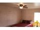 Bedroom with ceiling fan, textured cinder block walls and tile flooring, with a large window letting in natural light at 829 Dover Pl, Las Vegas, NV 89107