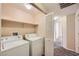A laundry room with a stacked washer and dryer and an open shelf for storage at 830 Carnegie St # 824, Henderson, NV 89052